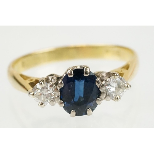 292 - 18ct gold sapphire and diamond three stone ring. The ring being set with an oval cut sapphire flanke... 