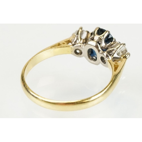 292 - 18ct gold sapphire and diamond three stone ring. The ring being set with an oval cut sapphire flanke... 