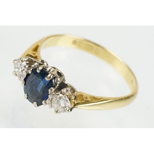 292 - 18ct gold sapphire and diamond three stone ring. The ring being set with an oval cut sapphire flanke... 