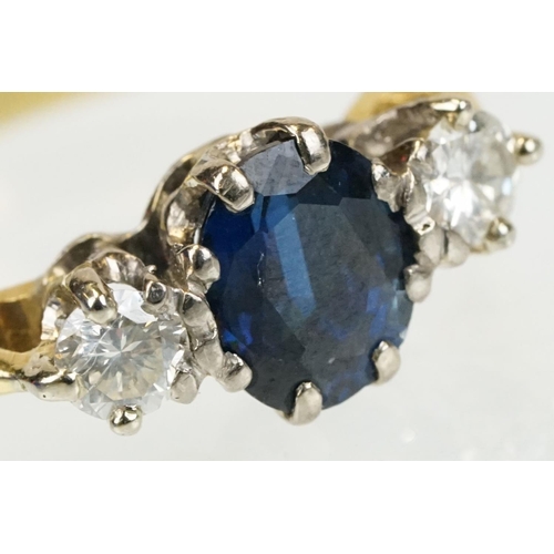 292 - 18ct gold sapphire and diamond three stone ring. The ring being set with an oval cut sapphire flanke... 