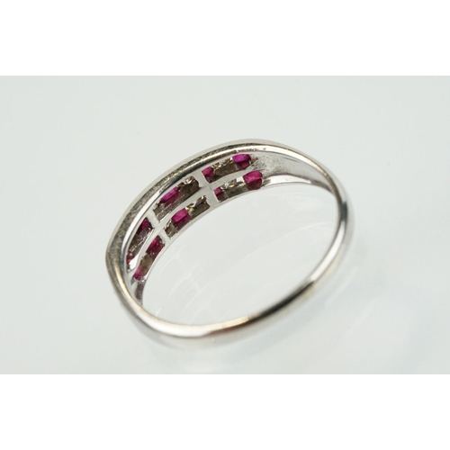 295 - 14ct white gold diamond and ruby double line ring being channel set with eight round brilliant cut r... 