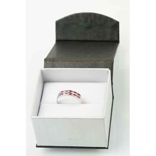 295 - 14ct white gold diamond and ruby double line ring being channel set with eight round brilliant cut r... 