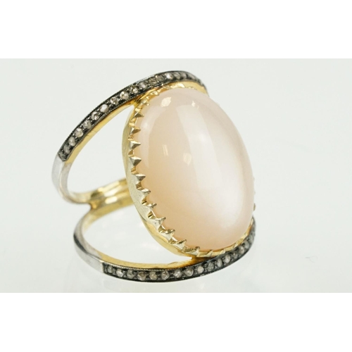 312 - Silver gilt diamond and moonstone set dress ring having a large moonstone cabochon to centre on a sp... 