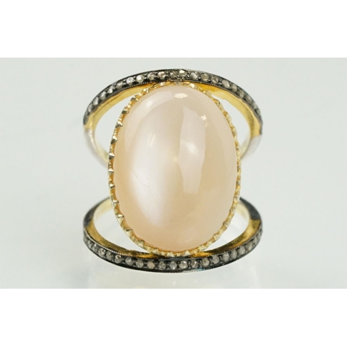 312 - Silver gilt diamond and moonstone set dress ring having a large moonstone cabochon to centre on a sp... 