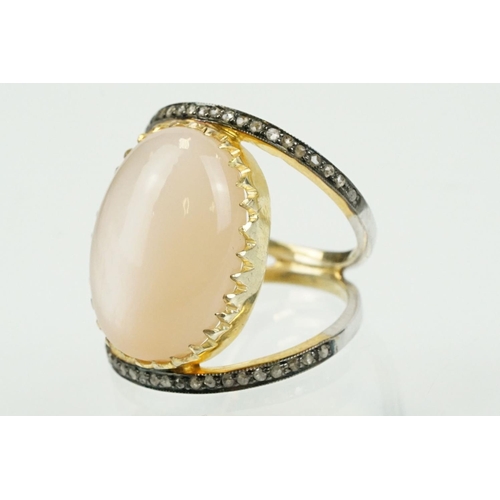 312 - Silver gilt diamond and moonstone set dress ring having a large moonstone cabochon to centre on a sp... 