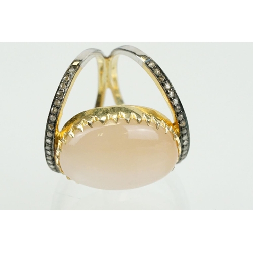 312 - Silver gilt diamond and moonstone set dress ring having a large moonstone cabochon to centre on a sp... 