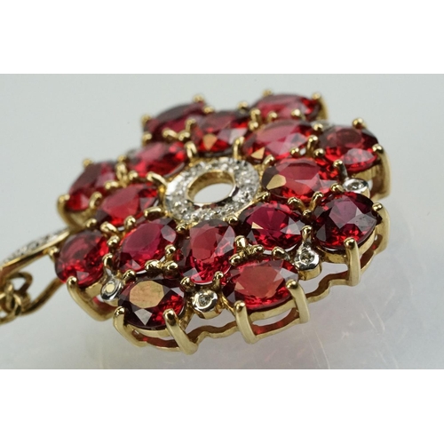 325 - 9ct gold ruby and diamond cluster pendant being set with sixteen oval cut rubies around a centre of ... 