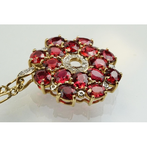 325 - 9ct gold ruby and diamond cluster pendant being set with sixteen oval cut rubies around a centre of ... 