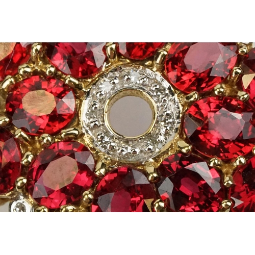 325 - 9ct gold ruby and diamond cluster pendant being set with sixteen oval cut rubies around a centre of ... 