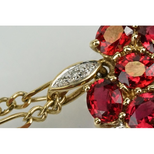 325 - 9ct gold ruby and diamond cluster pendant being set with sixteen oval cut rubies around a centre of ... 