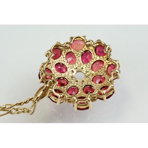 325 - 9ct gold ruby and diamond cluster pendant being set with sixteen oval cut rubies around a centre of ... 