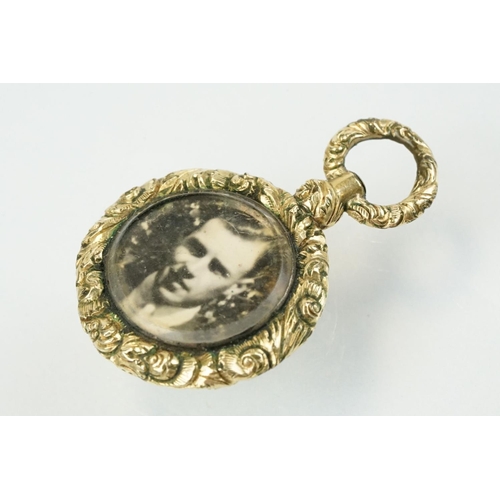 336 - 19th Century gold plated photo locket of round form being floral engraved and with an engine turned ... 