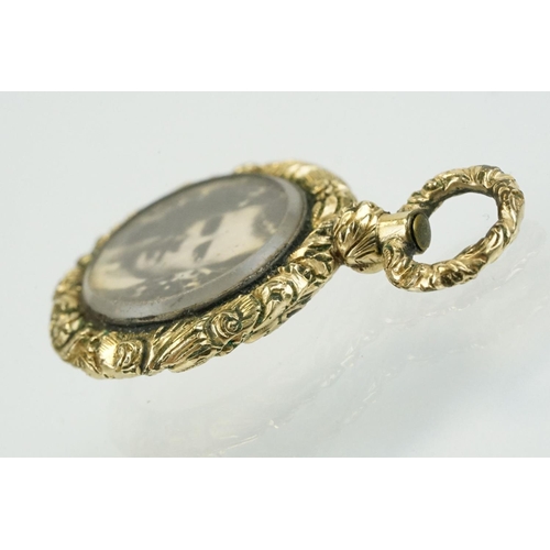 336 - 19th Century gold plated photo locket of round form being floral engraved and with an engine turned ... 