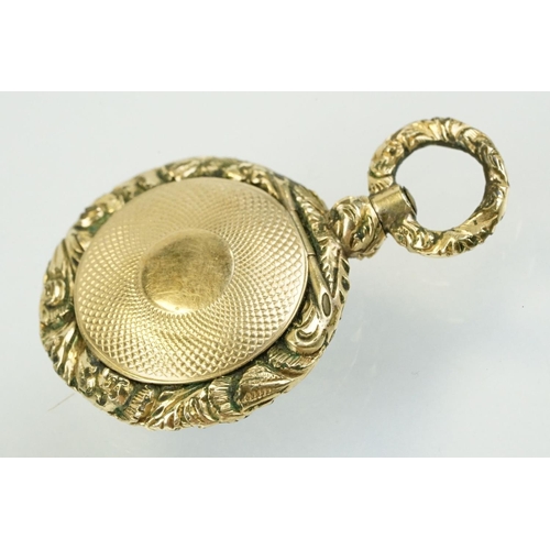 336 - 19th Century gold plated photo locket of round form being floral engraved and with an engine turned ... 