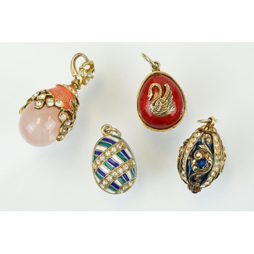 337 - Four enamelled egg pendants to include a Russian enamelled egg set with white stones (Russian hallma... 