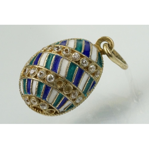 337 - Four enamelled egg pendants to include a Russian enamelled egg set with white stones (Russian hallma... 