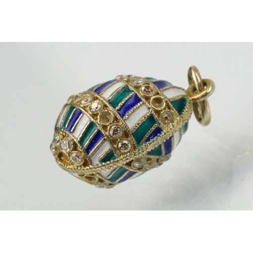 337 - Four enamelled egg pendants to include a Russian enamelled egg set with white stones (Russian hallma... 