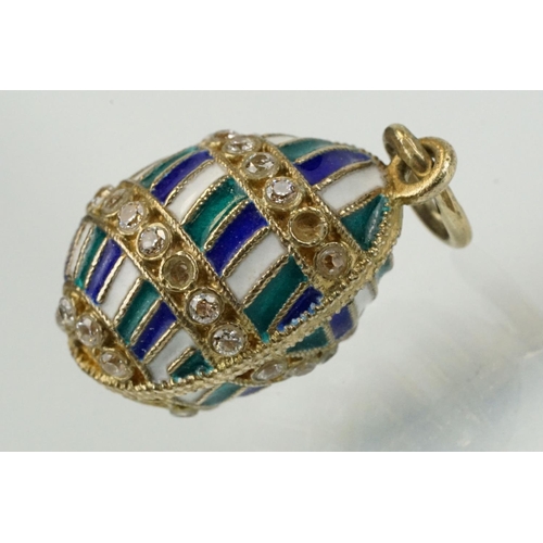 337 - Four enamelled egg pendants to include a Russian enamelled egg set with white stones (Russian hallma... 