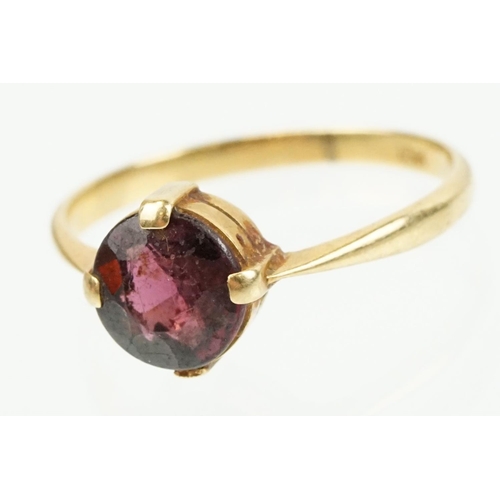 341 - 18ct gold and purple stone ring being having a round cut purple stone in a four prong setting (marke... 