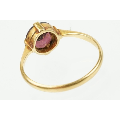 341 - 18ct gold and purple stone ring being having a round cut purple stone in a four prong setting (marke... 