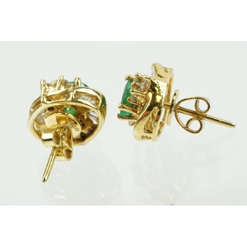 345 - Pair of 18ct gold emerald and diamond cluster earrings each being set with a central oval cut emeral... 