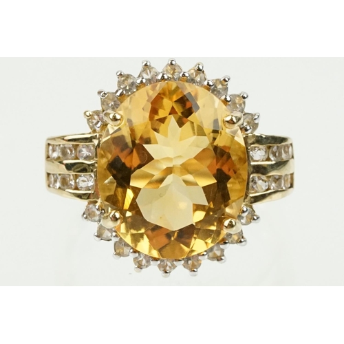 348 - 9ct gold, citrine and clear topaz dress ring. The ring being set with an oval cut citrine surrounded... 