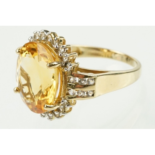 348 - 9ct gold, citrine and clear topaz dress ring. The ring being set with an oval cut citrine surrounded... 