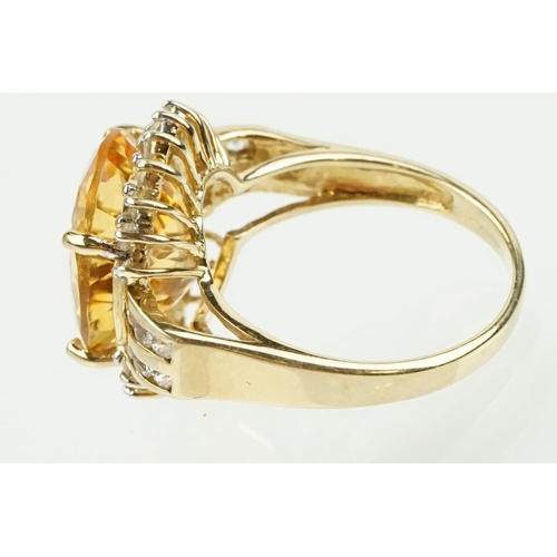 348 - 9ct gold, citrine and clear topaz dress ring. The ring being set with an oval cut citrine surrounded... 