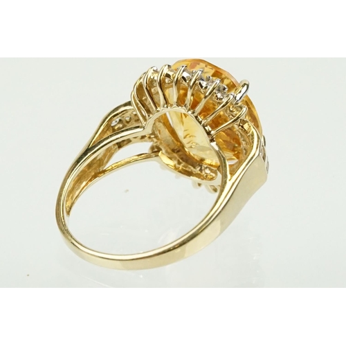 348 - 9ct gold, citrine and clear topaz dress ring. The ring being set with an oval cut citrine surrounded... 