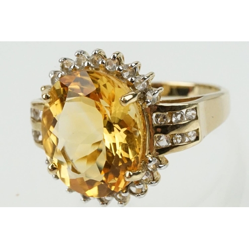 348 - 9ct gold, citrine and clear topaz dress ring. The ring being set with an oval cut citrine surrounded... 