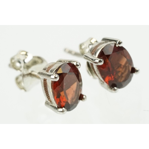 354 - Pair of silver and garnet set stud earrings, each being set with a single oval cut garnet stone. Mar... 