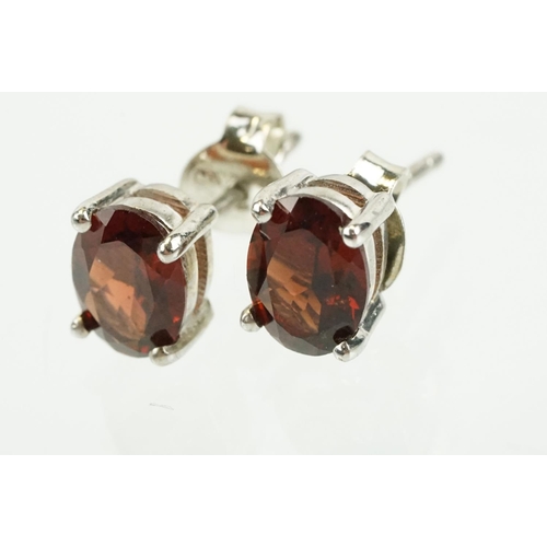 354 - Pair of silver and garnet set stud earrings, each being set with a single oval cut garnet stone. Mar... 