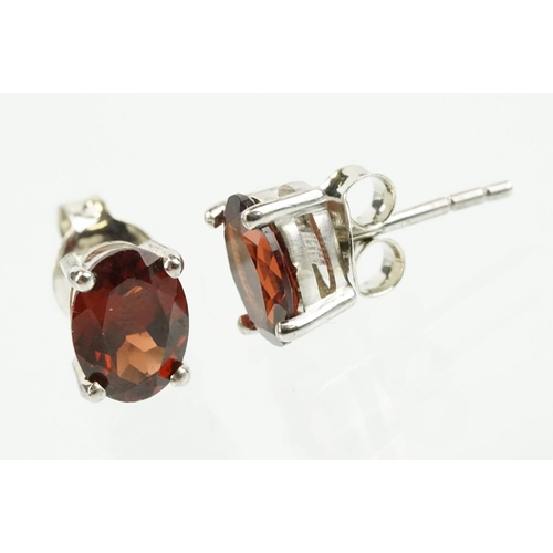 354 - Pair of silver and garnet set stud earrings, each being set with a single oval cut garnet stone. Mar... 