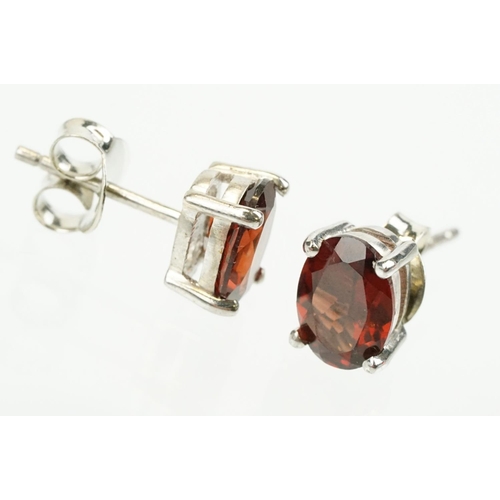 354 - Pair of silver and garnet set stud earrings, each being set with a single oval cut garnet stone. Mar... 