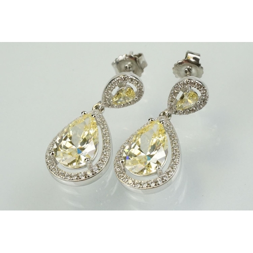 358 - Pair of silver and CZ set earrings, each having a yellow pear shaped stone to centre with a halo of ... 