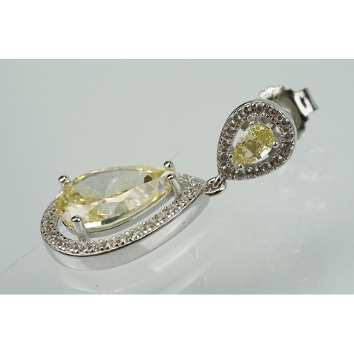 358 - Pair of silver and CZ set earrings, each having a yellow pear shaped stone to centre with a halo of ... 