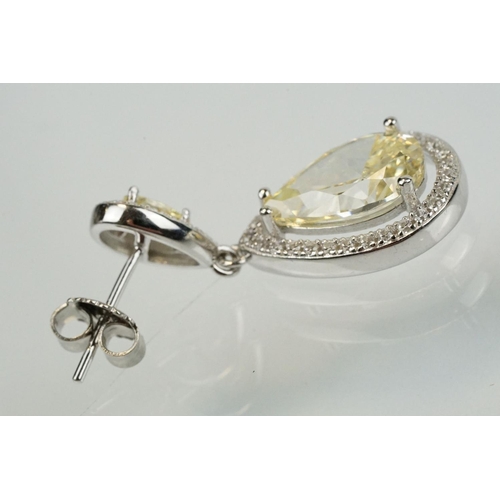 358 - Pair of silver and CZ set earrings, each having a yellow pear shaped stone to centre with a halo of ... 