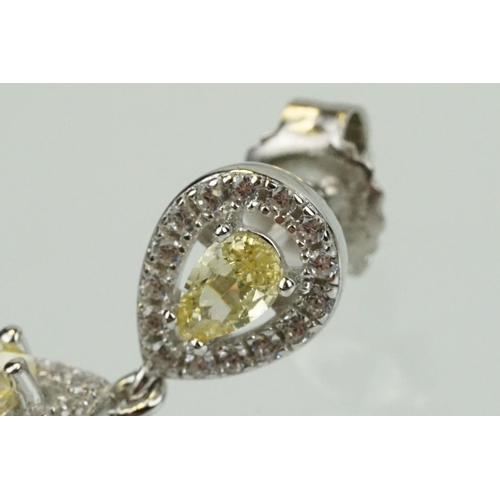 358 - Pair of silver and CZ set earrings, each having a yellow pear shaped stone to centre with a halo of ... 