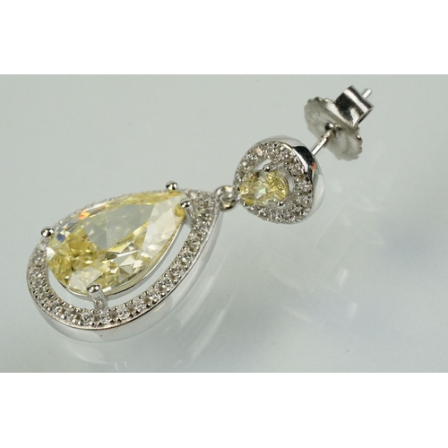 358 - Pair of silver and CZ set earrings, each having a yellow pear shaped stone to centre with a halo of ... 