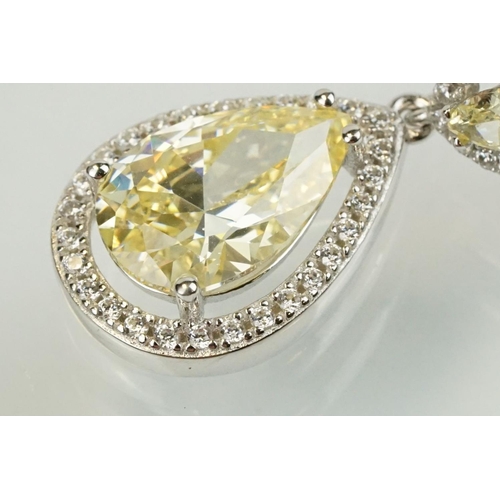 358 - Pair of silver and CZ set earrings, each having a yellow pear shaped stone to centre with a halo of ... 