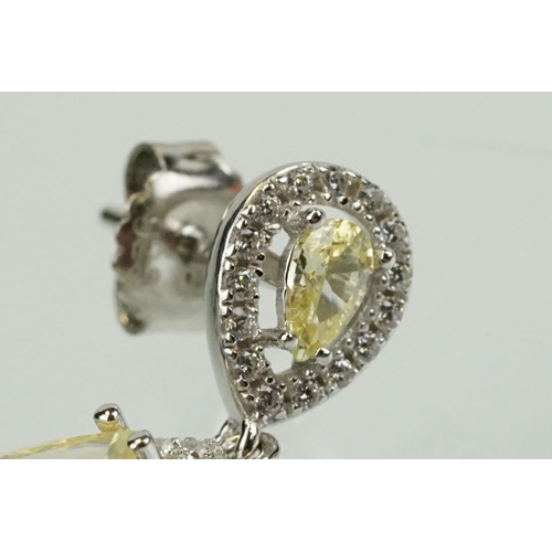 358 - Pair of silver and CZ set earrings, each having a yellow pear shaped stone to centre with a halo of ... 