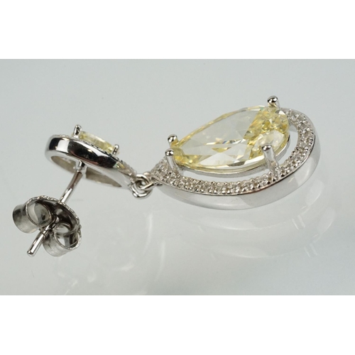 358 - Pair of silver and CZ set earrings, each having a yellow pear shaped stone to centre with a halo of ... 