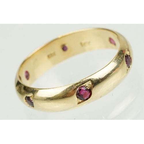 359 - Ruby 14ct yellow gold eternity ring, six small round mixed cut rubies, flush bead set, width approx ... 