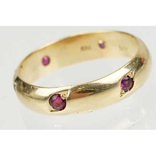 359 - Ruby 14ct yellow gold eternity ring, six small round mixed cut rubies, flush bead set, width approx ... 