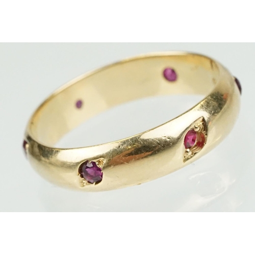 359 - Ruby 14ct yellow gold eternity ring, six small round mixed cut rubies, flush bead set, width approx ... 