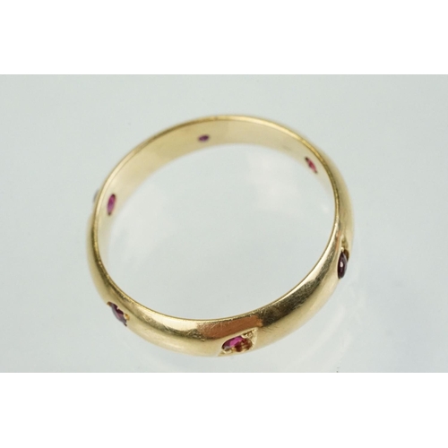 359 - Ruby 14ct yellow gold eternity ring, six small round mixed cut rubies, flush bead set, width approx ... 