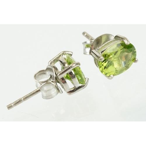 360 - Pair of silver and peridot stud earrings being set with oval cut peridots. Marked 925. Measures 7mm.