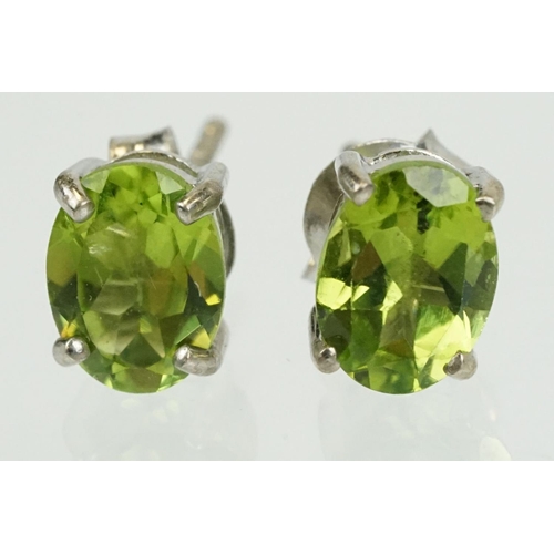 360 - Pair of silver and peridot stud earrings being set with oval cut peridots. Marked 925. Measures 7mm.