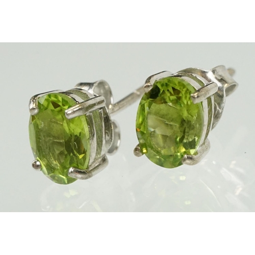 360 - Pair of silver and peridot stud earrings being set with oval cut peridots. Marked 925. Measures 7mm.