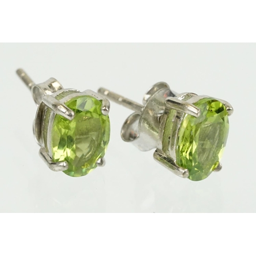 360 - Pair of silver and peridot stud earrings being set with oval cut peridots. Marked 925. Measures 7mm.